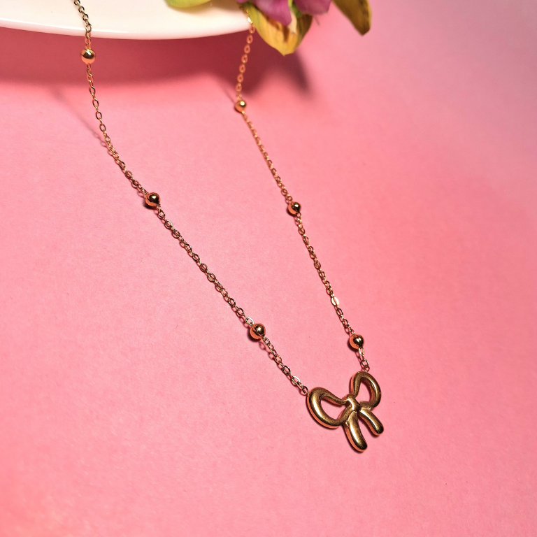 Stainless steel necklace with gold bow tie design